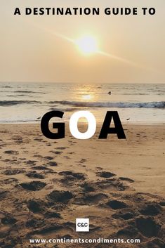 the words goa written in front of a beach at sunset with footprints on the sand