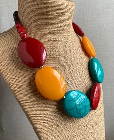 Large Oval bead statement Necklace. Colours: Turquoise, Mango Orange, Red, Marooon, Brown. The main beads are oval in shape, the Red and Turquoise beads have a crackle effect. Metal spacer beads. Fastens with a metal hook. Length: 59 cm. Largest bead: 5cm x 4 cm. HANDMADE & FAIRTRADE Items posted to addresses within the UK will be sent Royal Mail 1st Class UK Standard. International post will be sent Royal Mail International Tracked. Luxury Beaded Necklaces With Large Oval Beads, Cheap Red Beaded Necklace With Large Beads, Cheap Red Beaded Necklaces With Large Beads, Big Bead Necklace, Large Bead Necklace, Beaded Jewels, Handmade Fashion Jewelry, Beaded Statement Necklace, Coral Beads