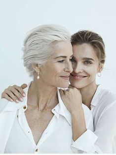 an older woman and younger woman are smiling for the camera, with their arms around each other