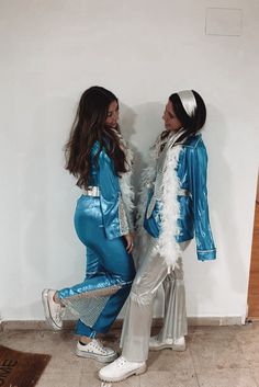 two women dressed in blue and silver posing for the camera