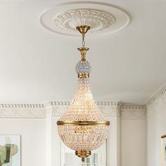 a chandelier hanging from the ceiling in a room with white walls and furniture