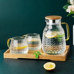 a pitcher and two glasses on a wooden tray