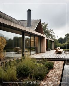 a house with large windows and wooden deck