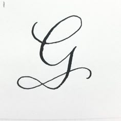 the letter g is written in cursive writing with black ink on white paper