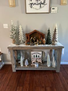 a christmas scene is displayed on top of a wooden shelf in the entryway to a house