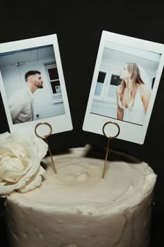 there is a cake with two pictures on it and a white rose in the middle