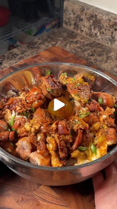 a person holding a metal bowl filled with food