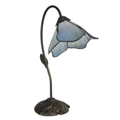 a lamp that is sitting on top of a metal stand with a flower in it