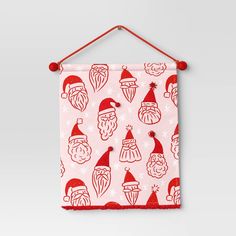 a red and white christmas banner hanging on a wall with santa's hat designs