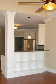 an empty living room and kitchen area in a new home with hard wood flooring