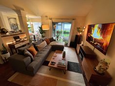 a living room filled with furniture and a flat screen tv mounted to the side of a wall