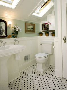 a white toilet sitting under a bathroom window next to a sink