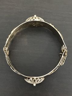 Thus Middle Eastern bracelet is so UNIQUE! It has 2 hamsas, 2 camels and 2 domes. The clasp is a pin attached to a chain that pulls out to unlatch. We are unsure of the material it is made of, but it is a nice weight; 47.7 grams. This piece is very special and will be a conversation piece, for sure. Silver Bracelet With Butterfly Clasp, Adjustable Silver Jewelry With Butterfly Clasp, Adjustable Chain Bracelet With Box Clasp, Adjustable Bangle Bracelet With Box Clasp, Adjustable Bangle Bracelets With Box Clasp, Adjustable Bracelet With Butterfly Clasp, Formal Adjustable Nickel-free Chain Bracelet, Ornate Adjustable Bracelets For Ceremonial Occasions, Ornate Adjustable Nickel-free Bracelets