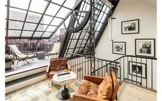 a living room filled with lots of furniture and pictures on the wall next to a window