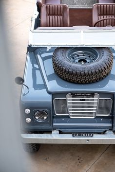 an old truck with two tires on the back and four seats in the bed area