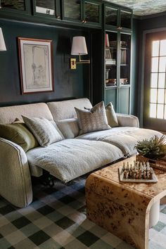 a living room filled with furniture and a checkered rug on the floor next to a coffee table