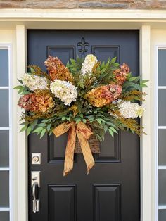 a front door decorated with flowers and greenery