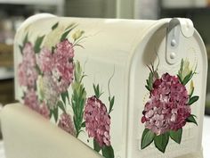 a white mailbox with pink flowers painted on it