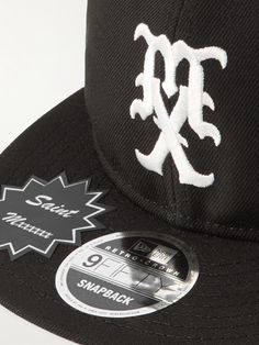 a black hat with white embroidered letters and a sticker on the visor that says snapback