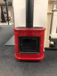 a red stove sitting on top of a carpeted floor