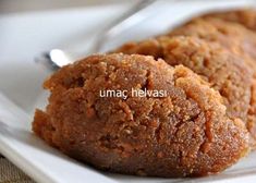 two cookies on a white plate with a spoon in the foreground and words underneath it