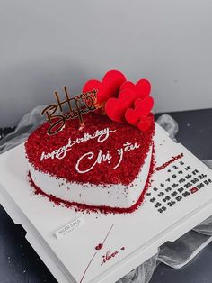 a heart shaped cake with red frosting and hearts on top