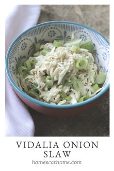 a blue and white bowl filled with food on top of a table next to a napkin