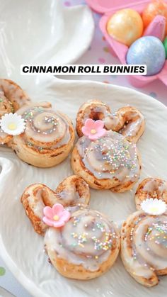 cinnamon roll buns on a white plate with pink flowers and sprinkles