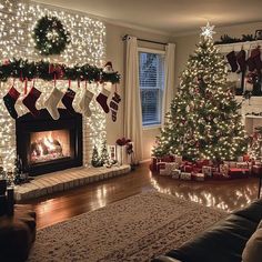 Christmas Tree And Mirror, Flocked Tree Colored Lights, In House Christmas Decorations, Christmas Indoor Decorations Ideas, Christmas Bar Decorations House, Fake Fireplace Christmas Decor, Christmas Decor For Dorm Room, Christmas Decor Ideas Apartment Living Room, Office Party Christmas Decorations