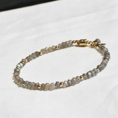 Gorgeous labradorite is hand strung to create this beaded bracelet. Accented with 14kt gold filled touches. D E T A I L S *Hand strung *natural labradorite *14kt gold filled accent beads *Fits up to a 7 inch wrist If you would like a longer length we can use a lobster clasp and add an extender, just leave us a note! ∙ EXTRA LOVE ∙ Handcrafted just for you in sunny Arizona by a team of talented women. All of our jewelry comes gift packaged! We are happy to leave a note if this is a special gift, Hand Wrapped Labradorite Bead Jewelry, Hand-wrapped Labradorite Round Beads Jewelry, Handmade Adjustable Labradorite Beaded Bracelets, Elegant Adjustable Labradorite Beaded Bracelets, Elegant Labradorite Beaded Bracelets, Hand-strung Labradorite Gold Jewelry, Adjustable Beaded Labradorite Bracelets, Bracelets With Round Natural Stones And Labradorite, Gold Labradorite Beaded Bracelet, Spiritual Style