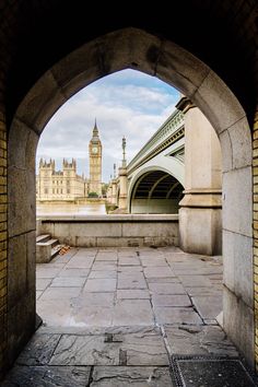 an archway leading to a clock tower in the distance