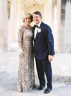 a man and woman standing next to each other in formal wear posing for the camera