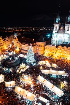 an aerial view of a christmas market in the middle of a city at night time