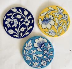 three different colored plates with designs on them