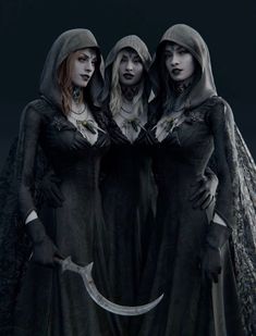 three women dressed in gothic clothing standing next to each other