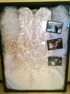 a wedding dress and other items are displayed in a shadow box on the floor next to a wall