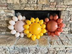 balloons are arranged in the shape of sunflowers on a stone fireplace mantel