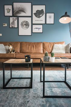 a living room filled with furniture and pictures hanging on the wall above it's coffee table