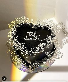 a black heart shaped cake with white sprinkles