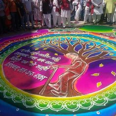 a group of people standing in front of a colorful circle with an image on it