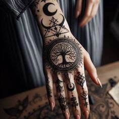 a person's hand with tattoos on it and the moon in the middle of their palm