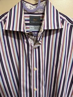 Thomas Dean Men's Medium Flip Cuff Purple Striped Button-Front Shirt. In very good preowned condition Measurements are approximate Armpit to armpit is Collar to bottom is 24” Smoke free home 32” No stains Small tag mark on the inside label and on back of shirt Really can’t notice it at all Formal Multicolor Cotton Shirt, Multicolor Formal Tops With Spread Collar, Formal Multicolor Tops With Spread Collar, Classic Multicolor Formal Shirt, Formal Multicolor Button-up Shirt, Button Front Shirt, On Back, Dean, Cuff