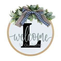 a wooden sign that says welcome to our home with the letter i on it and greenery