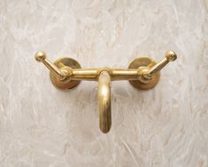 a gold handle on a white marble wall