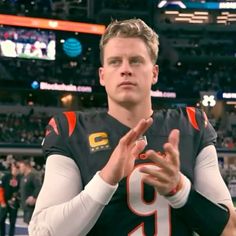 a football player holding his hands together in front of an audience at a game,