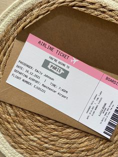 an airplane ticket sitting on top of a brown paper bag next to a white and pink tag