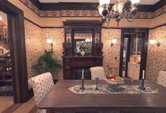 a dining room table with two chairs and a bowl of fruit on it