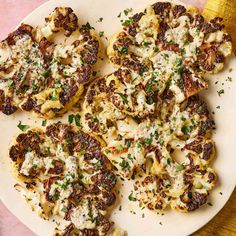 some food is on a white plate with green sprinkles and parmesan cheese