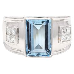 an aqua and white topazte ring with diamonds on the sides, set in 18k white gold