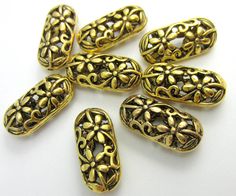 gold plated beads with filigrees and leaves on them are arranged in a circle